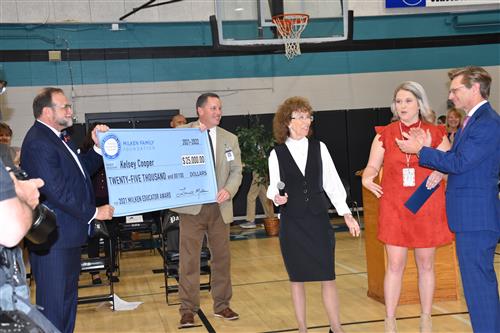 Kelsey Cooper with officials presenting her $25,000 check